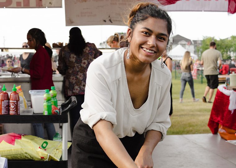 Woman cooking in wok at food festival