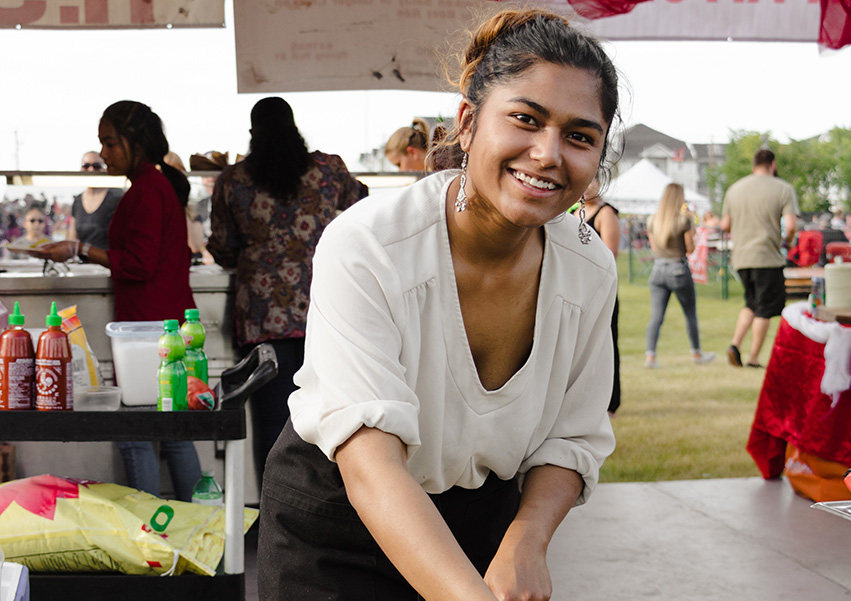 Woman cooking in wok at food festival