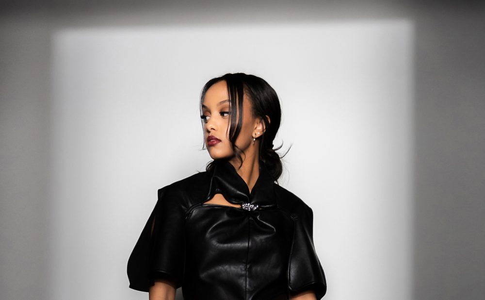 Ruth B posing in black dress