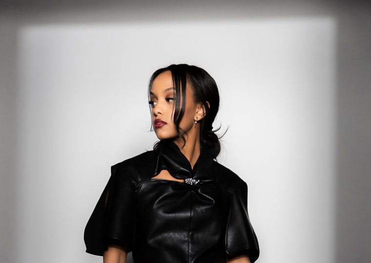 Ruth B posing in black dress