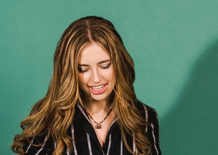 Ayla posing in front of green wall