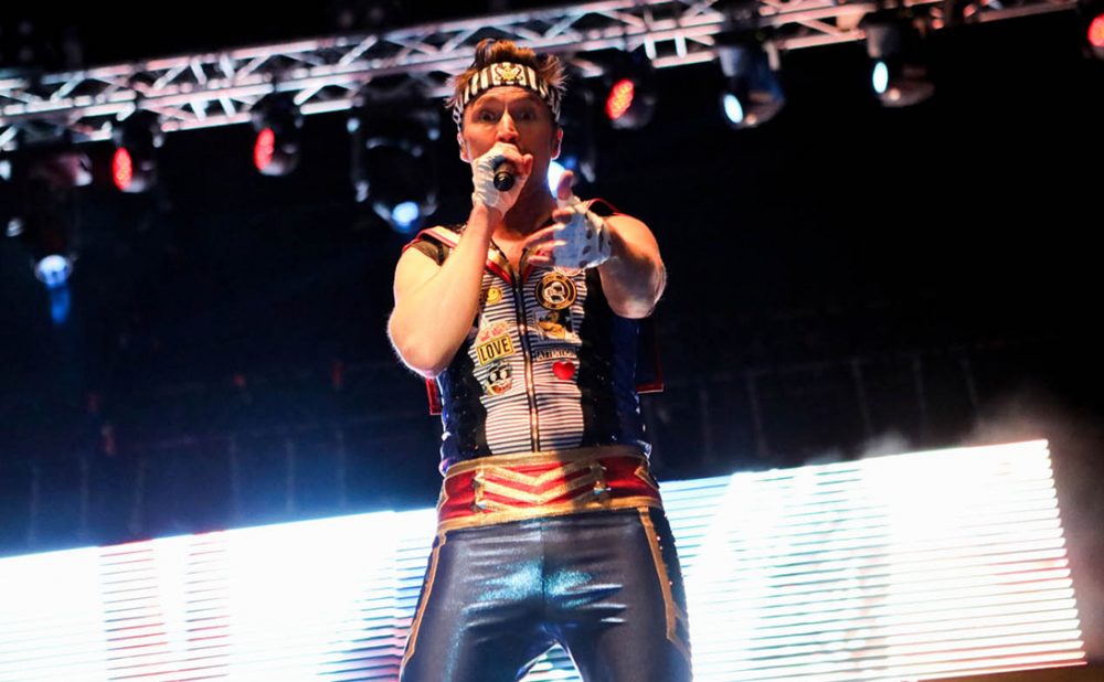 A member of the band Aqua performing on stage.