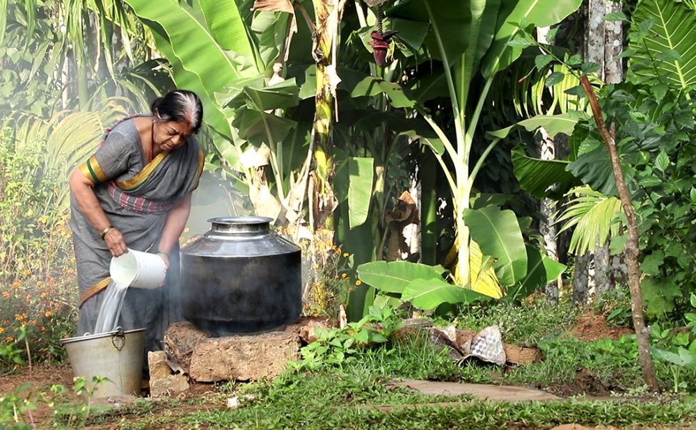 A woman cooking out in nature - a scene from the film The Chicken Curry.