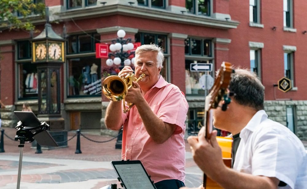 A man playing the trombone alongside a man playing the guitar in Gastown, Vancouver, B.C.