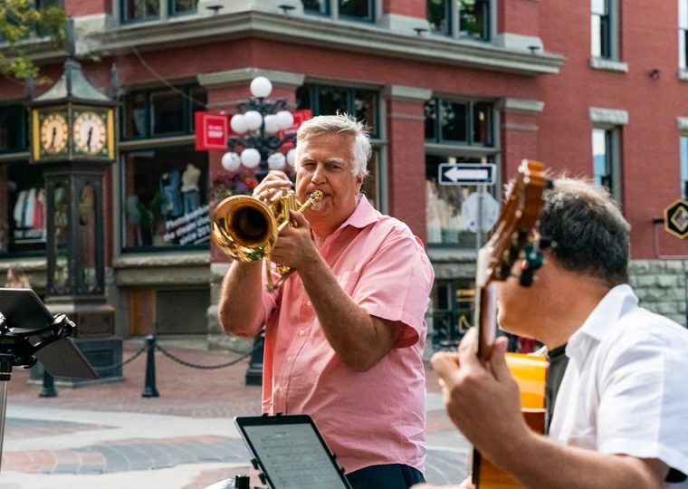 A man playing the trombone alongside a man playing the guitar in Gastown, Vancouver, B.C.