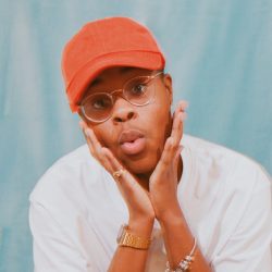 Kalisway holding his face in his hands, wearing an orange ball cap.