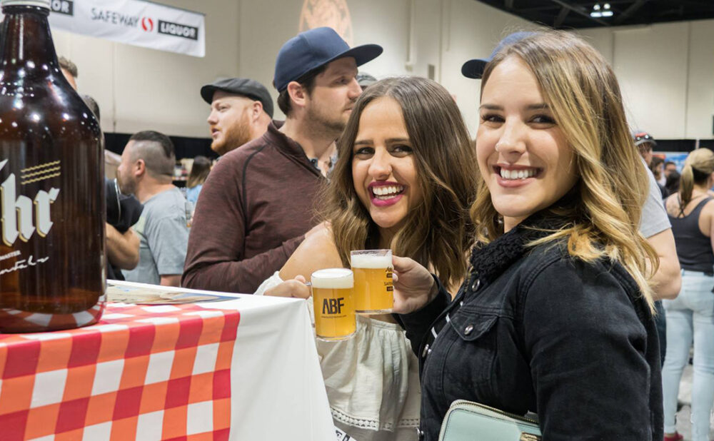 Two women cheersing beers at beerfest