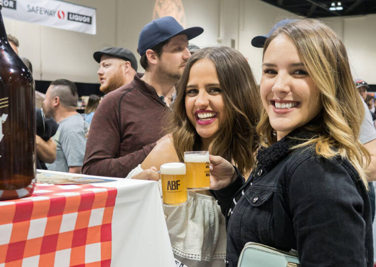 Two women cheersing beers at beerfest