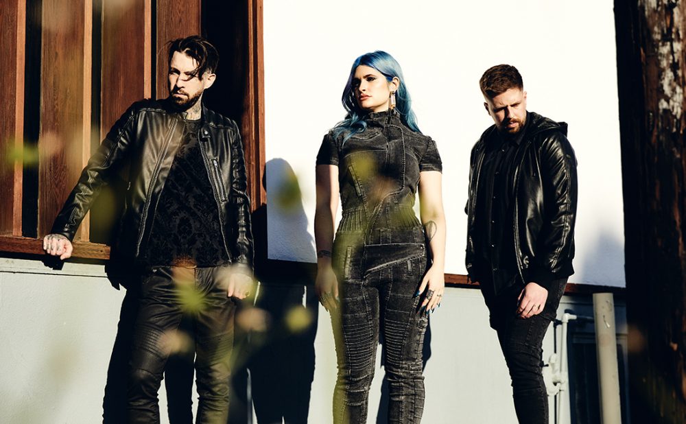 Bill Crook, Courtney LaPlante and Mike Stringer of Spiritbox standing outside, dressed in black.