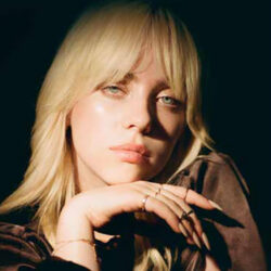 Close-up photo of a blonde Billie Eillish resting her chin on her hand
