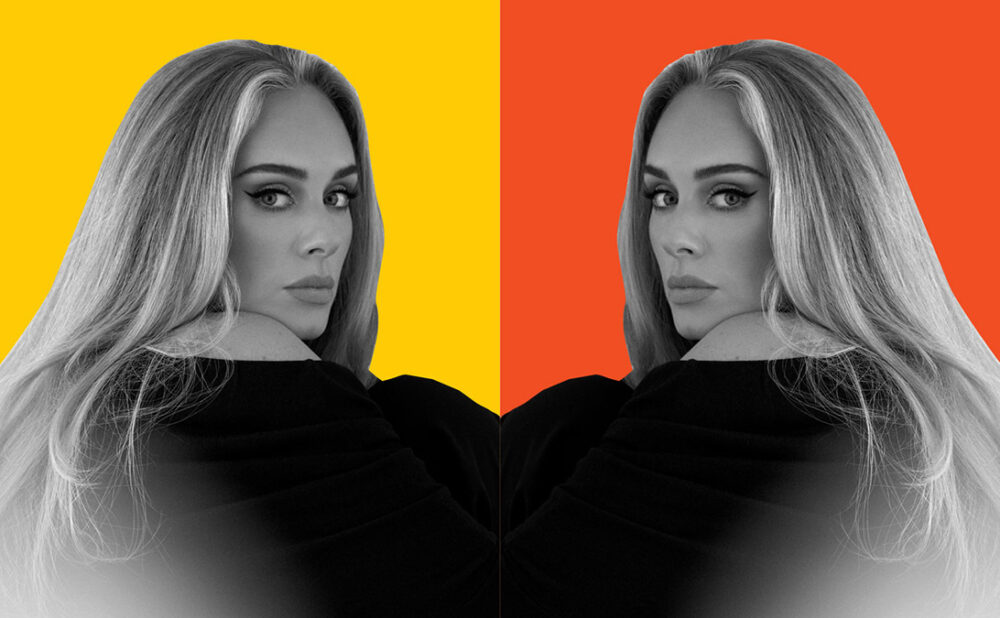 Mirrored photo of Adele in a black shirt looking over her shoulder at the camera.