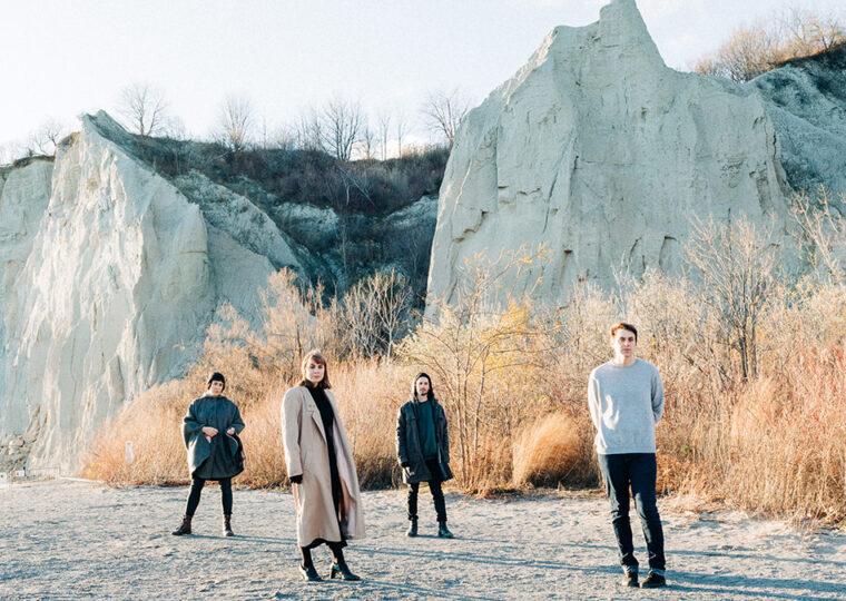 Casper Skulls band standing outside with bluffs in the background.