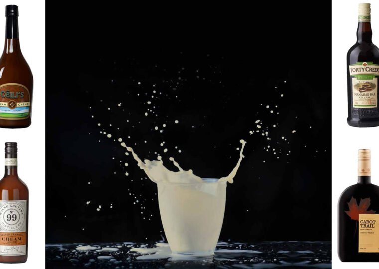 A glass of white milk looking liquid splashing out of the cup, on a black background, with four bottles of cream liquers surrounding it.