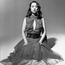 Black and white photo of Mitski seated on the floor.
