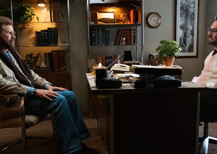 Scene from the show The Shrink Next Door, with Will Ferrell sitting across from Paul Rudd who's seated at a desk.