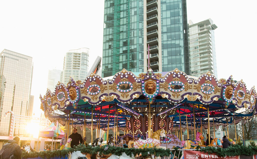 A carousel from the Vancouver Christmas Market with condo buildings in the back