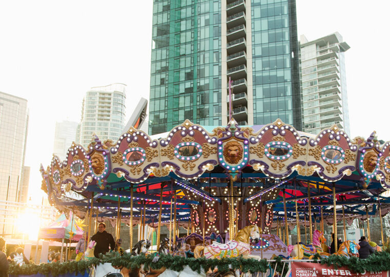 A carousel from the Vancouver Christmas Market with condo buildings in the back