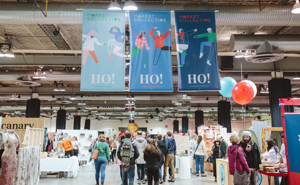People attending the Market Collective, walking through the aisle, checking out the booths.