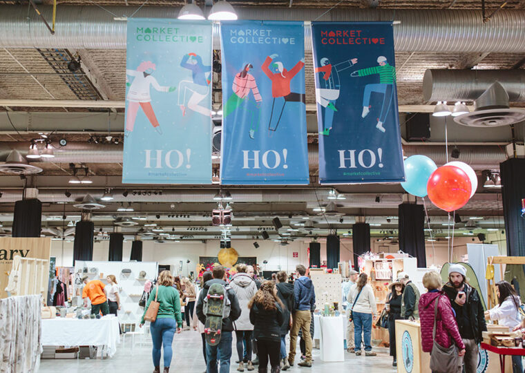 People attending the Market Collective, walking through the aisle, checking out the booths.