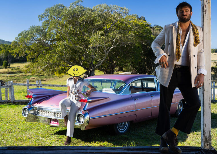Dope Lemon standing in front of a rose pink cadillac.