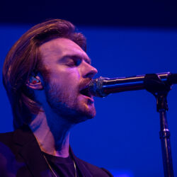 FInneas singing into a mic on stage.