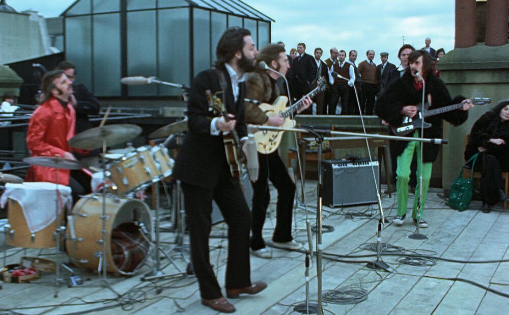 The Beatles performing on a rooftop.