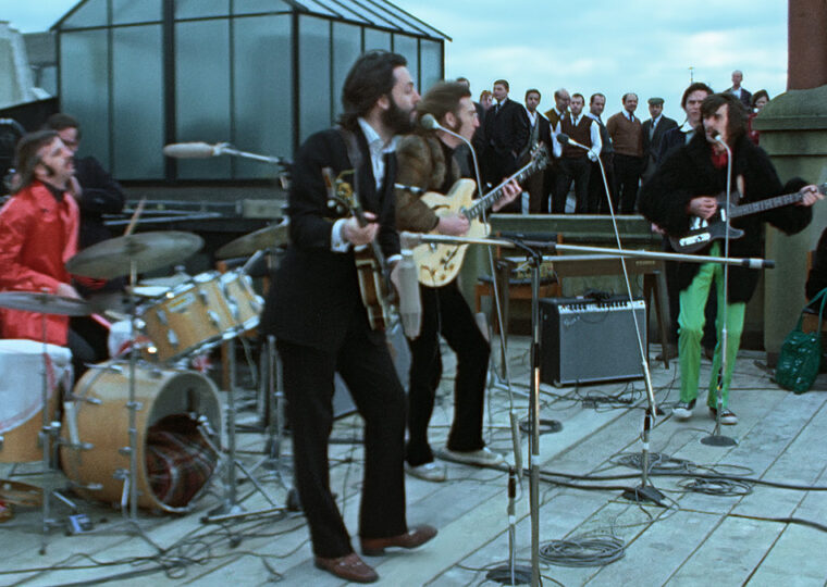 The Beatles performing on a rooftop.