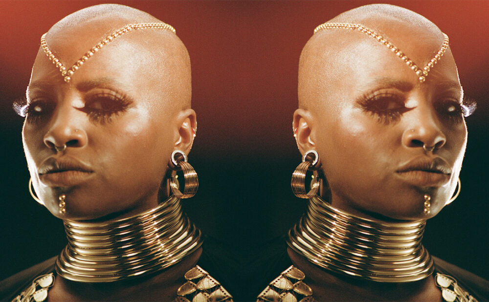 Headshot of Sate dressed in gold jewellery.