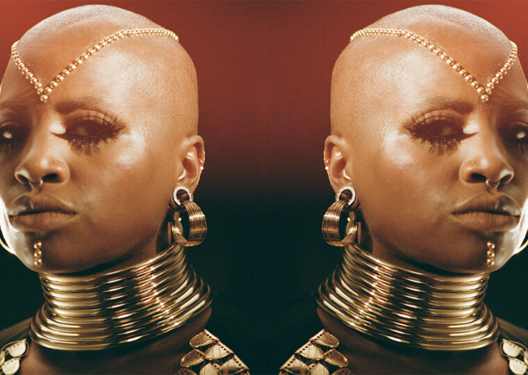 Headshot of Sate dressed in gold jewellery.