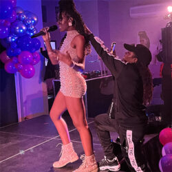 Haviah Mighty fixing sister Omega Mighty's hair during her live performance in Toronto.